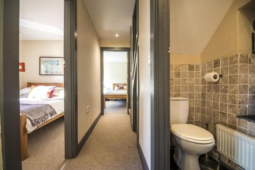 a bathroom with a toilet and a bed in a room at Rock Cottage - 3 Bedroom Holiday Home - Fishguard in Fishguard