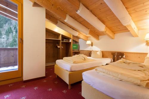 a hotel room with two beds and a window at Hotel Pinzger Tux in Tux