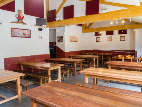 une salle à manger avec des tables et des chaises en bois dans l'établissement Auberge de Jeunesse HI Nîmes, à Nîmes