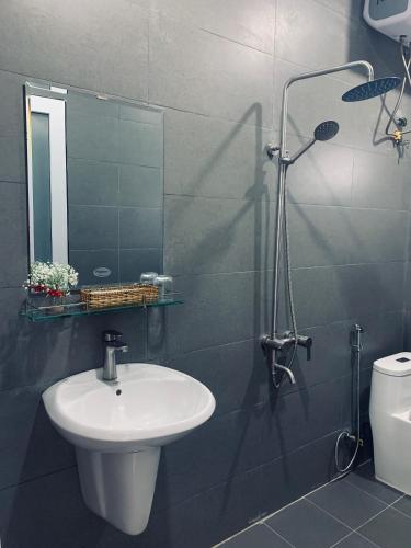 a bathroom with a sink and a shower with a mirror at November Villa Đà Lạt in Da Lat