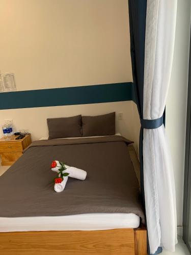 a bed with two towels and flowers on it at November Villa Đà Lạt in Da Lat