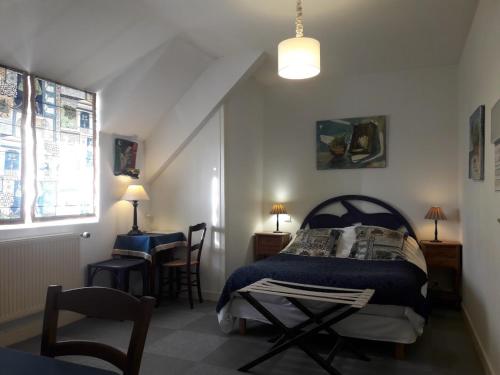 MeyssacにあるLogisHotels Le Relais du Quercyのベッドルーム1室(ベッド1台、テーブル、椅子付)