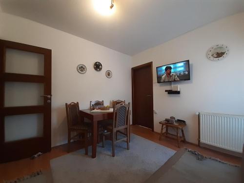 een kamer met een tafel en een televisie aan de muur bij Apartman Nik in Zlatibor