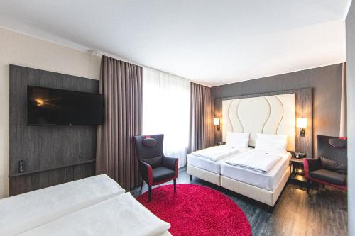 Säng eller sängar i ett rum på PLAZA Premium Parkhotel Norderstedt