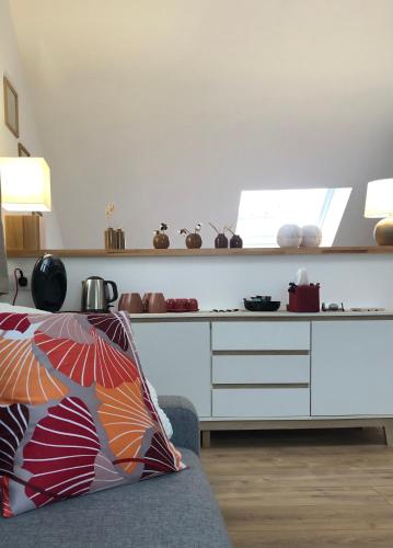 a living room with a couch and a kitchen at Ginkgo Maison d'hôtes in Amiens
