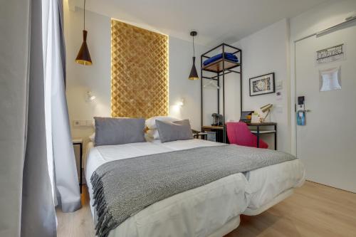 a bedroom with a large bed and a desk at Hotel Beausejour in Paris