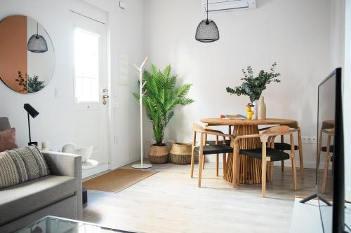 ein Wohnzimmer mit einem Tisch, Stühlen und einem Sofa in der Unterkunft Tinto Townhouse by Olala Homes in Sevilla