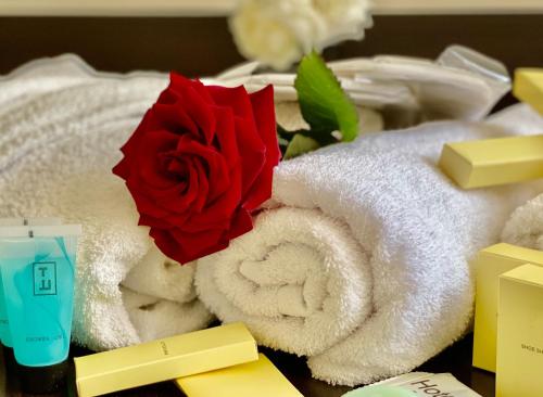 a red rose sitting on top of towels at Parvana Hotel in Gyumri