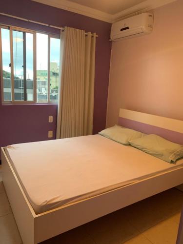 Cama en habitación con ventana y colchón en Apartamento em itapema, en Itapema