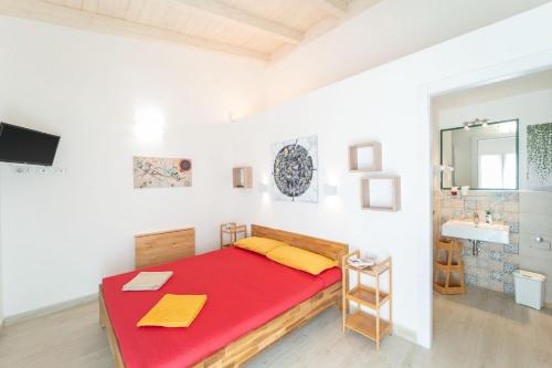 a bedroom with a red bed and a sink at Capriccio Mediterraneo in Sassari