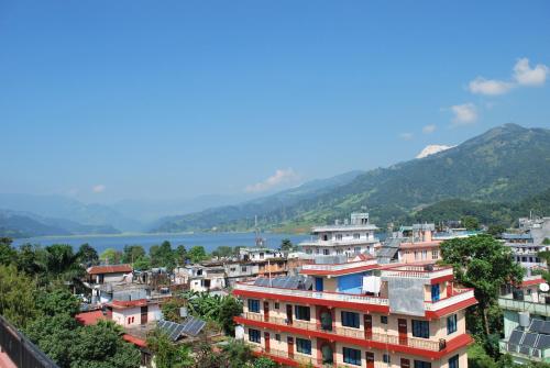 a group of houses on a hill next to a lake at Butterfly Lodge in Pokhara