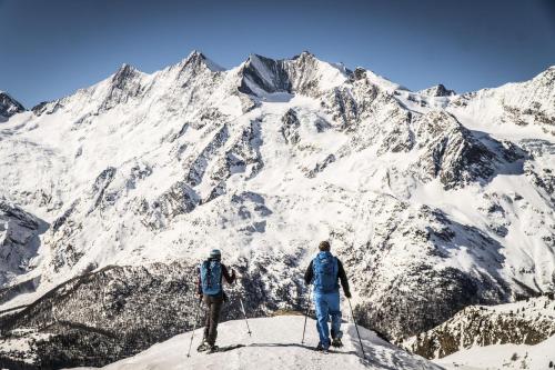 サースフェーにあるハウス ベル ヴューの雪山の頂上に立つ二人