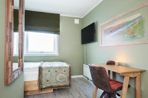 een kleine kamer met een bureau en een bed bij 8 SEASONS in Varangerbotn