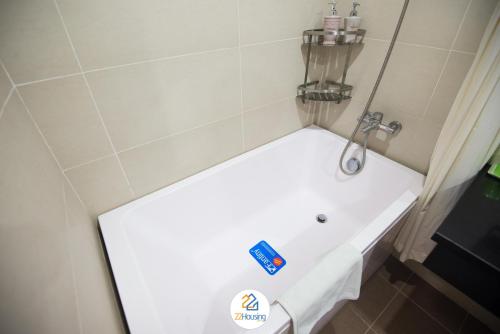 a white bath tub in a small bathroom at 22Housing luxury Hotel & Residence 39 Linh Lang in Hanoi
