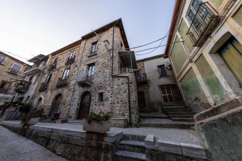 un antiguo edificio de piedra con escaleras en un callejón en San Giuseppe en Nicotera