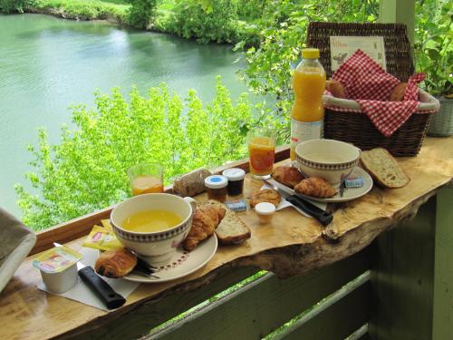 a table with a cup of tea and bread and drinks at Camping belle rivière in Chaniers