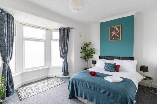 a bedroom with a bed with a blue wall at The Gatsby - Beautiful Spacious Central House in Cardiff