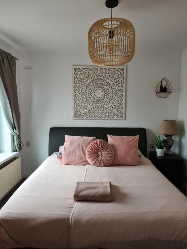 ein Schlafzimmer mit einem großen Bett mit rosa Kissen in der Unterkunft Evy's place in Zandvoort