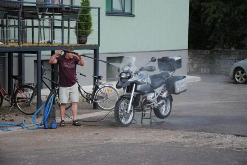 a man is standing next to a motorcycle at Arabella Hotel in Kuressaare