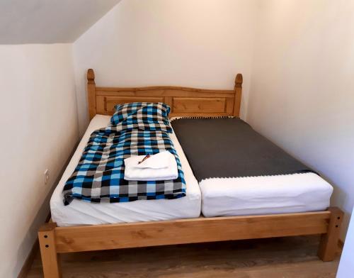 a small bed with a checkered blanket on it at Apartmány pod Mariánskými schody in Albrechtice v Jizerských horách