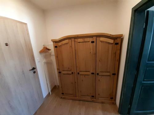 a wooden cabinet in a room next to a door at Apartmány pod Mariánskými schody in Albrechtice v Jizerských horách