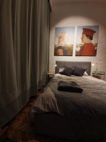 a bedroom with a bed with three pictures on the wall at Takie studio, że żal nie wynająć in Łódź