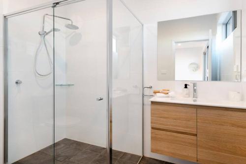 a bathroom with a glass shower and a sink at Brand new house, amazing views, walk to the beach! in Kiama