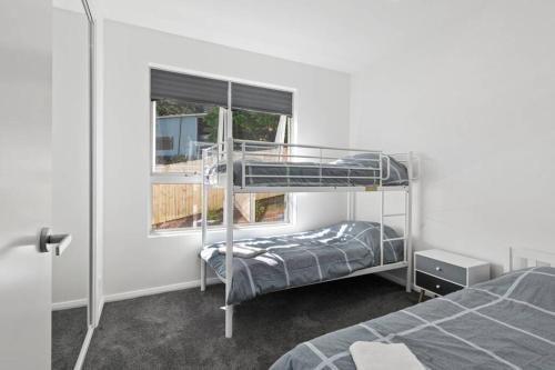 - une chambre avec 2 lits superposés et une fenêtre dans l'établissement Brand new house, amazing views, walk to the beach!, à Kiama