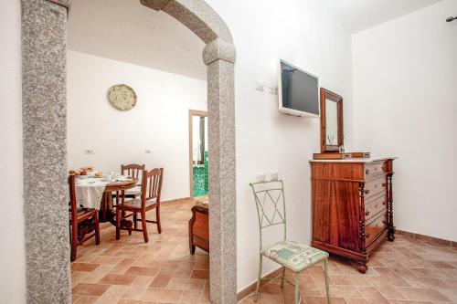 uma sala de estar com uma mesa e uma televisão na parede em Vincent House Boutique Hotel em Santa Teresa Gallura