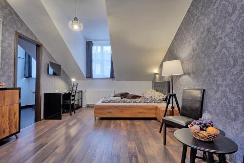 uma sala de estar com uma cama e uma mesa em Café Garden Residence em Cracóvia