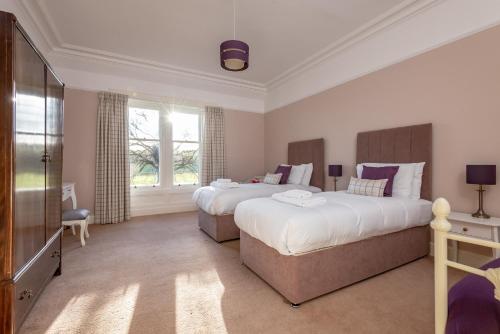 Habitación de hotel con 2 camas y TV en Easter Kincaple Farmhouse, Sleeps 16, St Andrews, en St Andrews