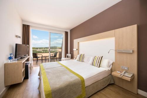 ein Hotelzimmer mit einem Bett und einem großen Fenster in der Unterkunft Hotel Mariant Park in Sa Coma