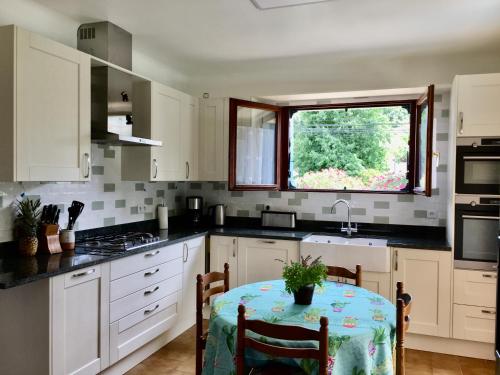 a kitchen with a table and a window at Détente au soleil in Sorède