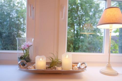 a table with candles and a lamp and a window at Hotel Hof Holm in Brasilien