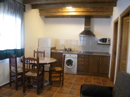 uma cozinha com uma mesa e um fogão forno superior em El Rincón de los Riveros em El Raso