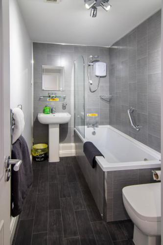 a bathroom with a tub and a sink and a toilet at 2 Bdrm Sleeps 7 Near Top Attractions Free Parking in Blackpool