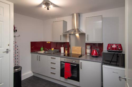 eine Küche mit weißen Schränken und einem Herd mit Backofen in der Unterkunft New Luxury Apt 1 Free Parking Special Deals in Blackpool