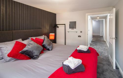 een slaapkamer met een groot wit bed met rode kussens bij 2 Bedrooms Sleeps 7 Near Top Blackpool Attractions in Blackpool