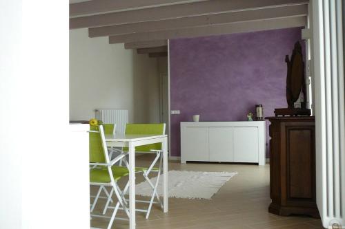 comedor con mesa blanca y sillas verdes en Charming 1-Bed Apartment in Castell'Arquato, en CastellʼArquato