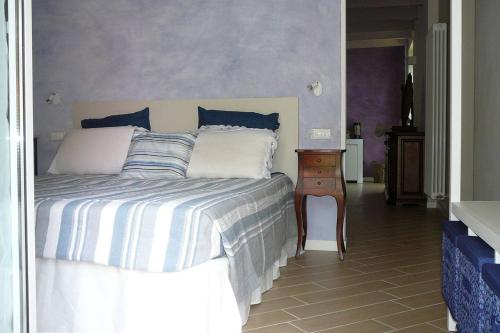 1 dormitorio con 1 cama con almohadas azules y blancas en Charming 1-Bed Apartment in Castell'Arquato, en CastellʼArquato