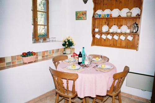 ein Esszimmer mit einem Tisch und einem rosa Tischtuch in der Unterkunft Beautiful 3-Bed Cottage in Passais-Villages in Saint-Siméon