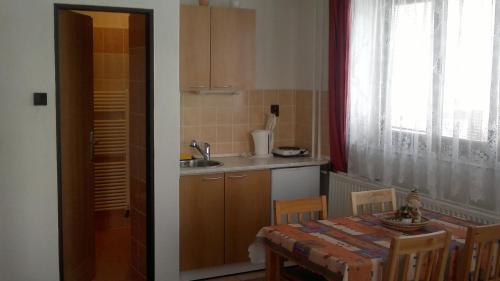 a kitchen with a table and a sink and a window at Apartmany U Ády in Železná Ruda