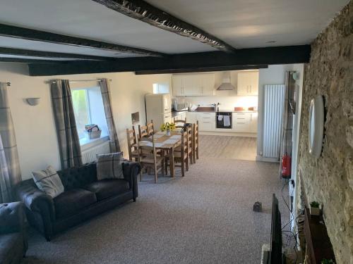 ein Wohnzimmer mit einem Sofa und einem Tisch sowie eine Küche in der Unterkunft Tuckers Grave Inn Nr Bath Longleat Cheddar Bristol in Norton Saint Philip