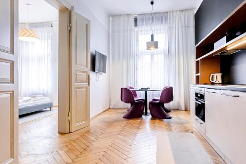 a kitchen with a table and two purple chairs at Modern apartment 10 minutes from Old Town! in Prague