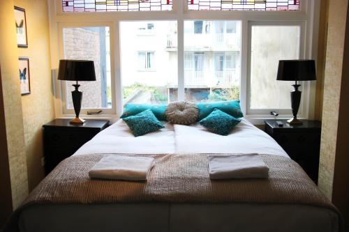 a bedroom with a large bed with pillows and a window at House of Freddy in Amsterdam