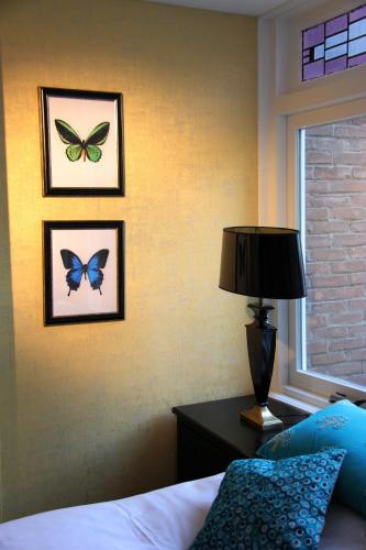 a bedroom with two pictures of butterflies on the wall at House of Freddy in Amsterdam