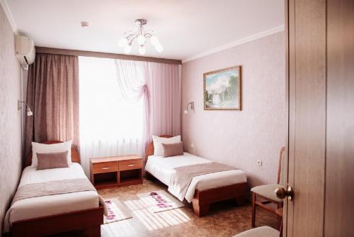 a hotel room with two beds and a window at Hotel Rus in Tolyatti