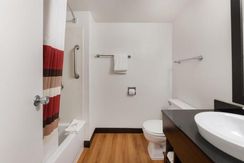 a bathroom with a white toilet and a sink at Red Roof Inn PLUS+ Columbus - Worthington in Columbus