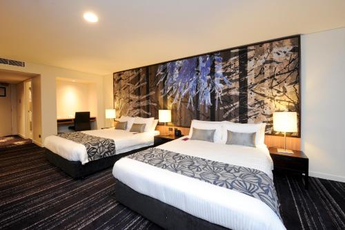 a hotel room with two beds and a painting on the wall at Mantra Gladstone in Gladstone