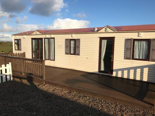 a house with a wooden deck in front of it at Farm stay property Pets and families welcome in Rossnowlagh